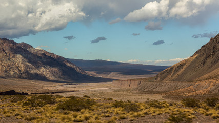 Beautiful scenic landscape of a valley in the Andes mountain under a blue sky with cloud in Mendoza Argentina