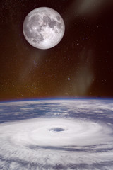 Wall Mural - view from space of a giant hurricane over the ocean with full moon in background. the elements of th