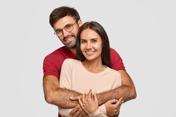 lovely couple have warm cuddle, pose for family portrait, smile joyfully, have good relationships. a