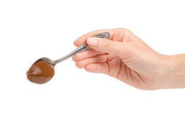 Boiled condensed milk in a spoon in hand on a white background. Isolation