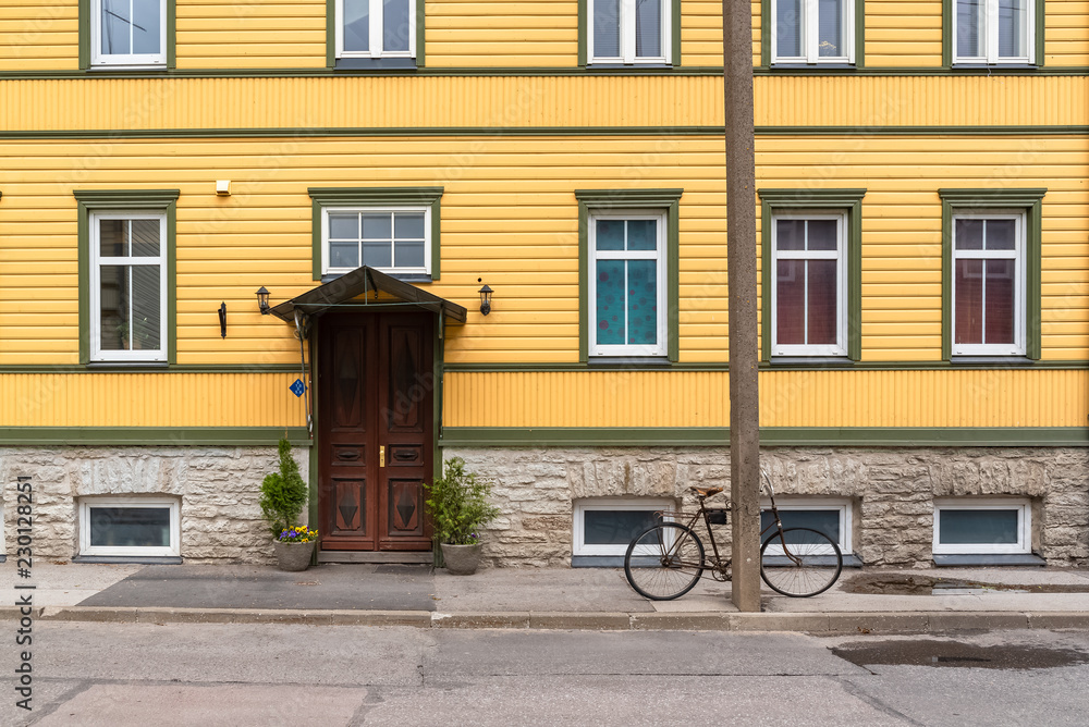 Obraz na płótnie Tallinn in Estonia, wooden colorful houses, typical facades in Kalamaja, with a bike
 w salonie