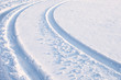 Car tire tracks in fresh snow.