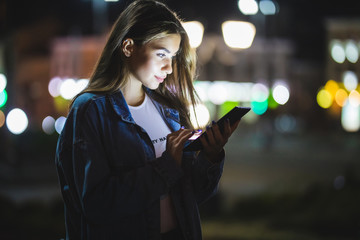 Wall Mural - Young girl using digital tablet on night beauty light bokeh in city