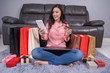 © geargodz - woman shopping online for gift with laptop in living room