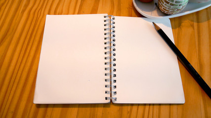 The notebook on the wooden table at the coffee shop.