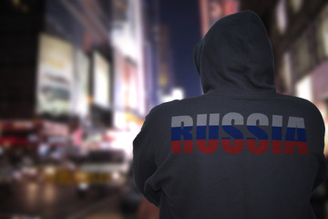 Wall Mural - dangerous man standing on a city street with black hoodie with text russia on his back