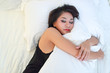 © feeling lucky - cute asian model with black see through dress sleeping and huging white pillows on bed