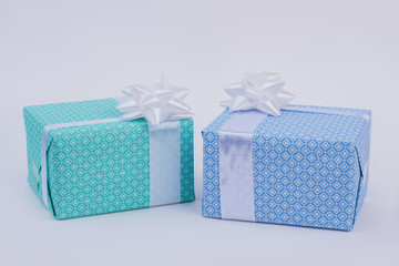 Gift boxes in blue paper on gray background. Present boxes wrapped in elegant paper with white bow. Happy Christmas concept.