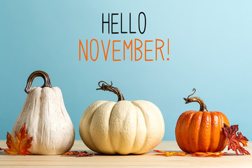 Wall Mural - hello november message with pumpkins on a blue background