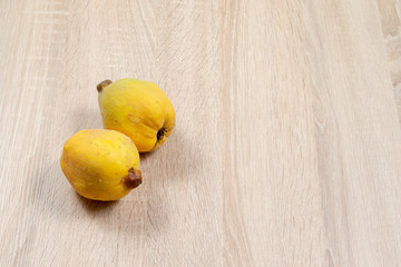 Ripe yellow quinces on wooden bacground with copyspace