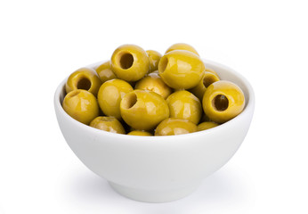 Green group of olives in a white ceramic bowl isolated on white background.