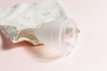 Wall Mural - Menstrual cup on pink background, feminine hygiene