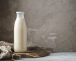 Fresh milk in glass bottle on rustic background