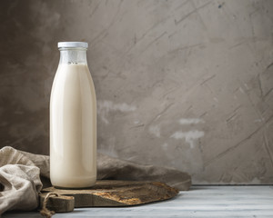 Fresh milk in glass bottle on rustic background