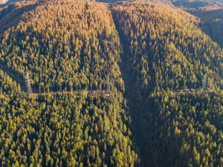 Wall Mural - Aerial view of power line pylon in mountaineous area in Switzerland through valley in Canton of Valais
