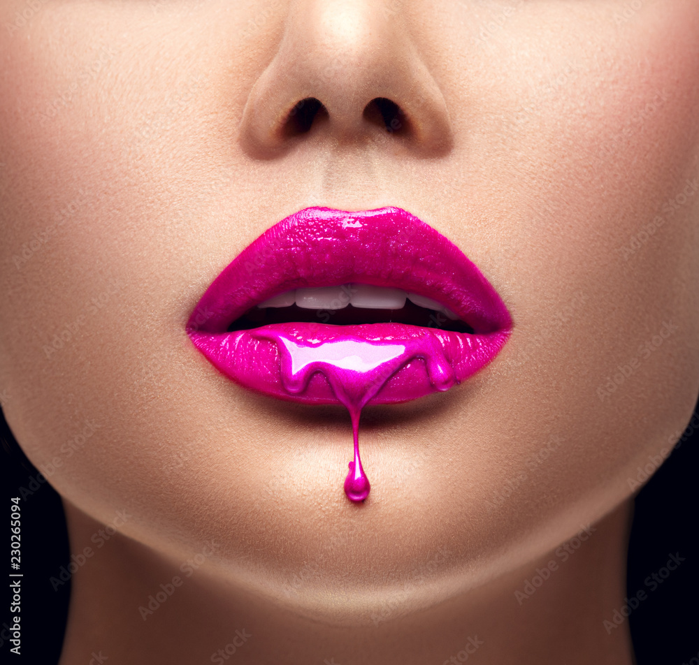 Pink lipstick dripping. Lipgloss dripping from sexy lips, Purple liquid drops on beautiful model girl's mouth, creative abstract makeup - obrazy, fototapety, plakaty 