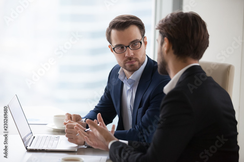 Cuadros en Lienzo Two serious caucasian men in suits discussing or planning business issues in the office