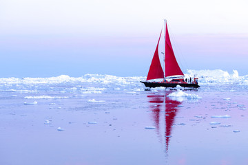 Wall Mural - beautiful red sailboat sailing among icebergs during dawn. ilulissat, greenland.