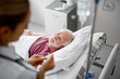 © Yakobchuk Olena - Portrait of joyful old man lying in hospital bed while female therapist regulating IV infusion. Focus on bearded gentleman
