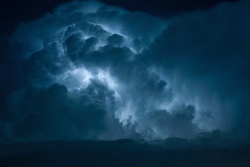 Blue Lightning strike surrounded by storm clouds.