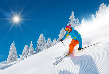 Skier skiing downhill in high mountains