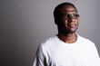 © Ranta Images - Young African man wearing white shirt and eyeglasses against gra
