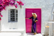 Attraktive, weibliche Touristin in einem Sommerkleid steht vor einer typisch, griechischen Kulisse auf den Kykladen in Griechenland, Naoussa, Paros 