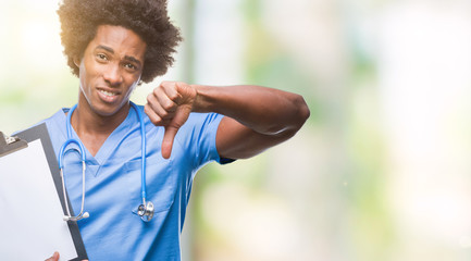 Afro american surgeon doctor holding clipboard man over isolated background with angry face, negative sign showing dislike with thumbs down, rejection concept