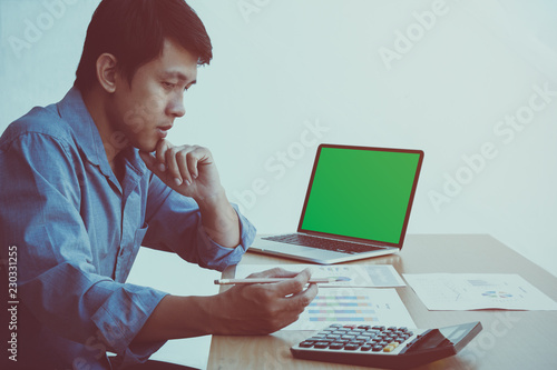 Fotografia Middle aged thinking businessman working on green screen laptop and checking the