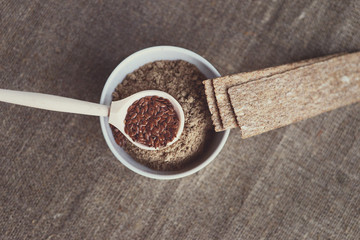 Wall Mural - a bowl of flax flour, a wooden spoon with flax seeds and dietary bread rolls on canvas