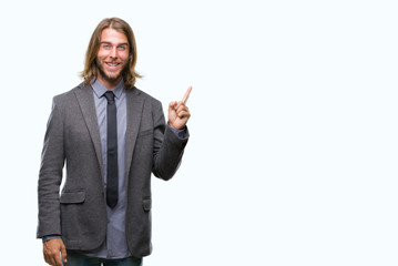 Canvas Print - Young handsome business man with long hair over isolated background with a big smile on face, pointing with hand and finger to the side looking at the camera.