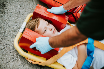 Wall Mural - Young injured boy lying on an ambulance stretcher