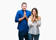 © Krakenimages.com - Young couple in love over isolated background praying with hands together asking for forgiveness smiling confident.