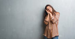 © Krakenimages.com - Young brunette woman over grunge grey wall sleeping tired dreaming and posing with hands together while smiling with closed eyes.