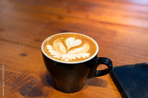cup of coffee with latter art on wooden background Poster Mural XXL