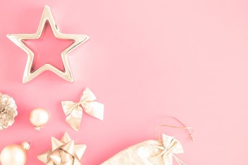 Christmas composition. Xmas gold decorations on pastel pink background. Flat lay, top view, copy space 