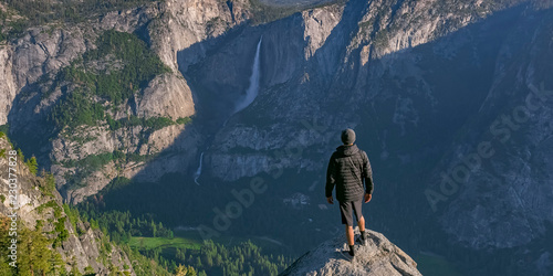 Photo Man on cliff overlooking Yosemite Falls and valley