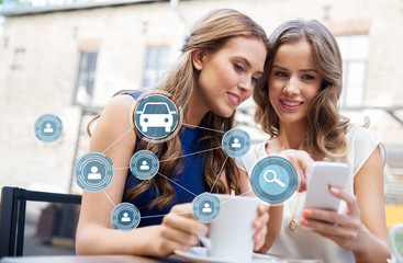 Poster - car sharing, modern technology and people concept - happy young women with smartphone drinking coffee at cafe outdoors