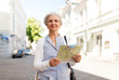 © Syda Productions - travel, tourism and retirement concept - senior woman or tourist with map on city street