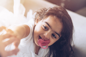 Wall Mural - Christmas and New Year. Little girl in cute dress at home lying on sofa touching mother's hand smiling excited close-up