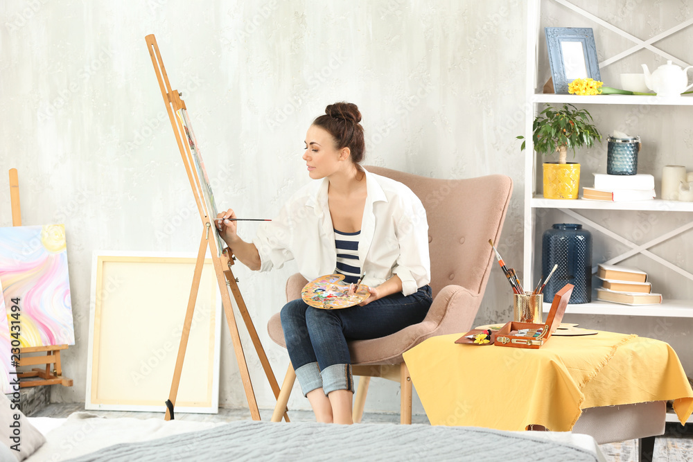 Female artist painting picture in workshop