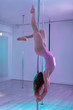 Dance teacher. Dark-haired pole dance teacher showing the right way of doing pole flow to her students