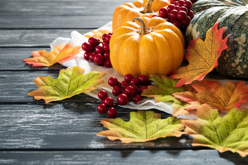 Wall Mural - autumn maple leaves with pumpkin and red berries on old wooden backgound. thanksgiving day concept.