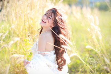 portrait of beautiful woman having a happy time and enjoying among grass field in nature