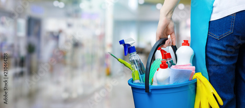 Fotografía A cleaning woman is standing inside a building holding a bucket fulfilled with chemicals and facilities for tidying