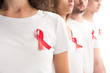 cropped image of people standing with red ribbons on white shirts isolated on white, world aids day concept