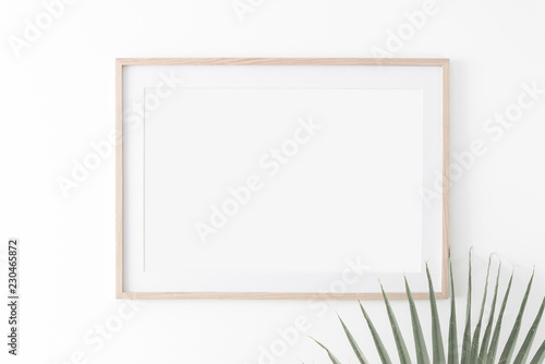 Landscape large 50x70, 20x28, a3,a4, Wooden frame mockup with passe-partout on white wall and palm leaf. Poster mockup. Clean, modern, minimal frame. Empty fra.me Indoor interior, show text or product