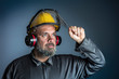 © tiero - studio portrait of a metalworker wearing a work overalls and a helmet with a protective safety visor.