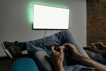 Two Men Playing Video Game. Clean Monitor Mockup. Hands Holding Console Controller. Blank Tv Screen Mock Up. Widescreen Tv Hang On The Wall.