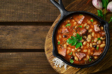 Baked Beans On Iron Skillet On Wooden Table